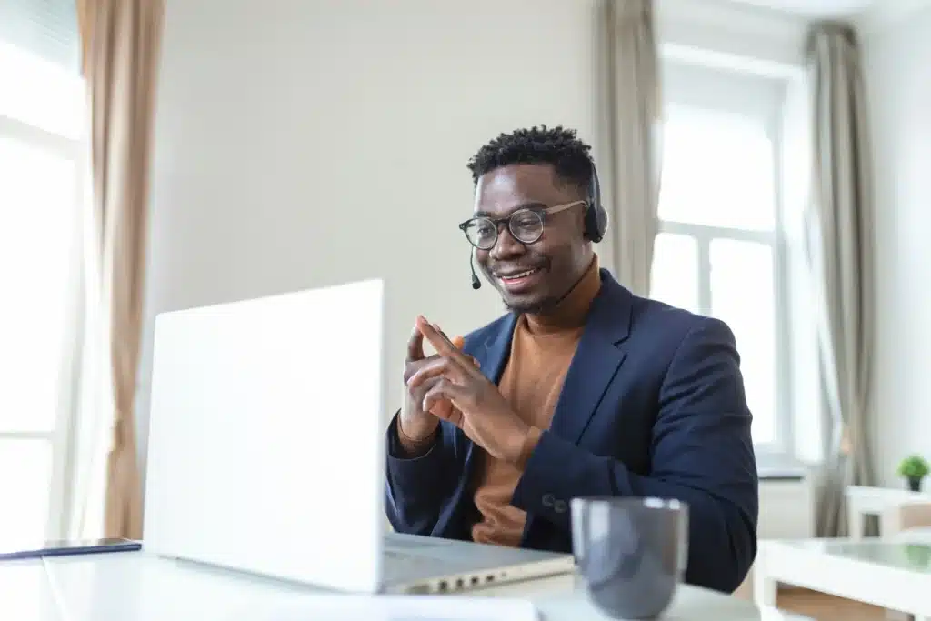 Photo of a remote employee working on laptop while smiling