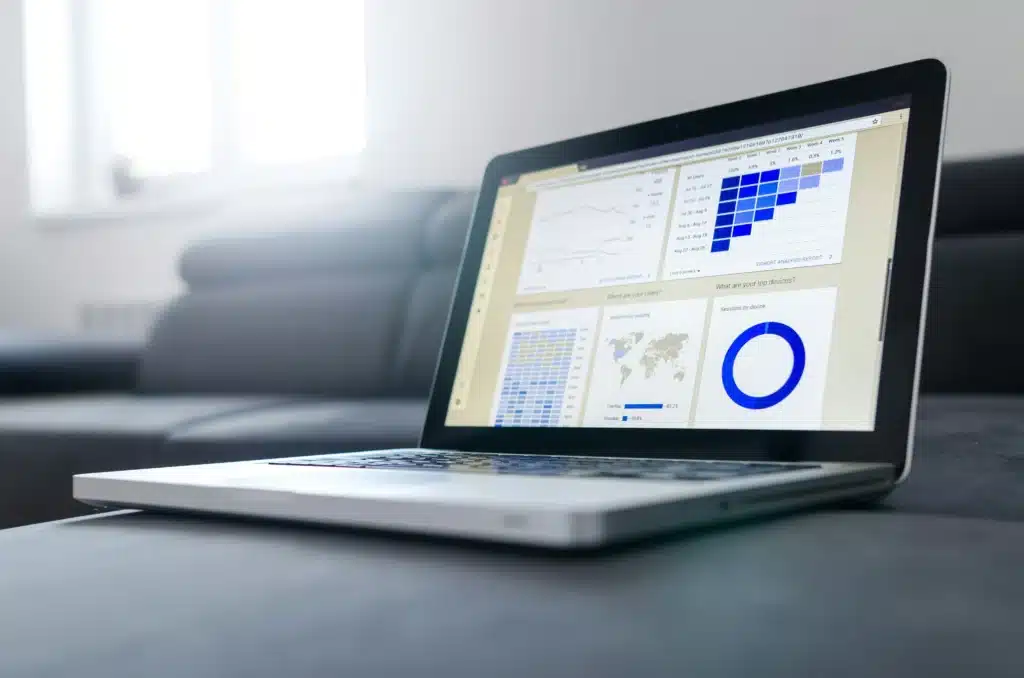 MacBook Pro on grey couch with business data open on screen