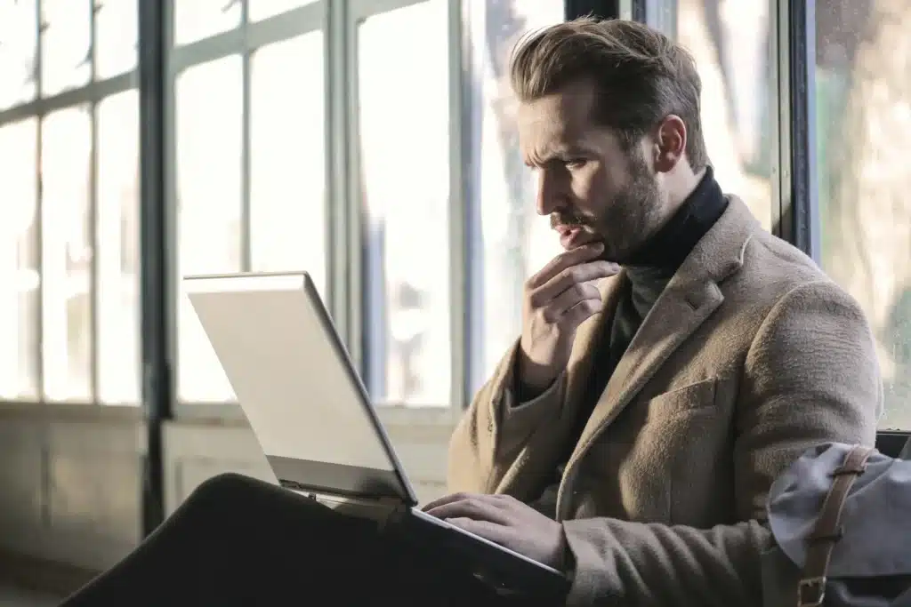 Man staring at laptop with confused look