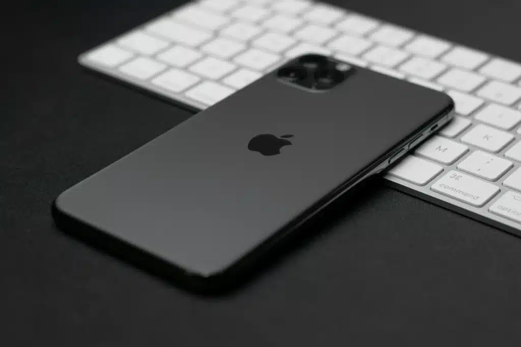 Black Apple iPhone on white Apple Magic keyboard